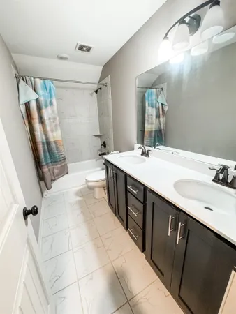 a bathroom with a double vanity sink a mirror and a shower