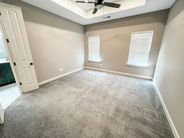 an empty room with a window and a ceiling fan