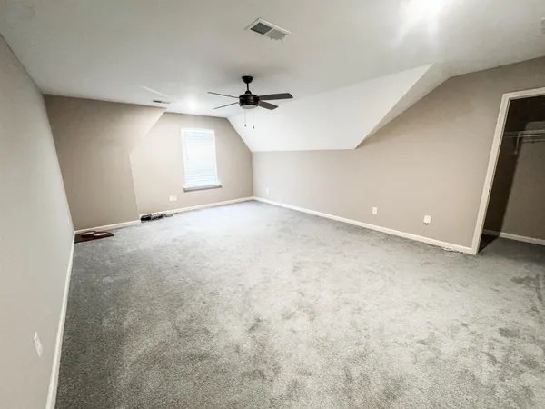 an empty room with windows and ceiling fan