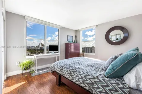 a bedroom with a bed and a table with wooden floor