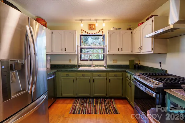a kitchen with stainless steel appliances granite countertop a stove a sink and a refrigerator