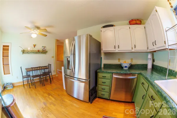 a kitchen with granite countertop a refrigerator a stove a sink and a dining table with garden view