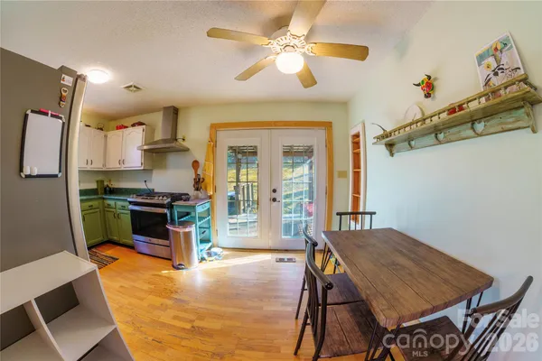 a kitchen with a table chairs refrigerator and cabinets