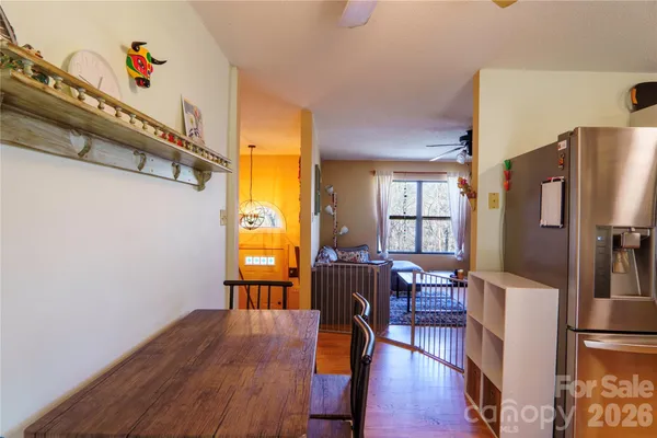 a view of a dining room with furniture a chandelier and wooden floor