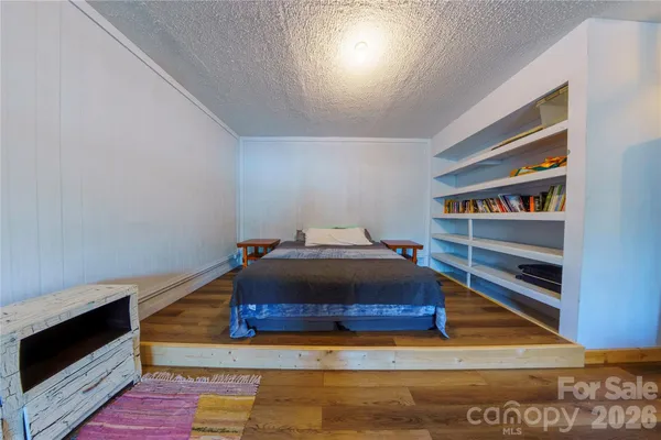 a living room with a bookshelf and a wooden floor