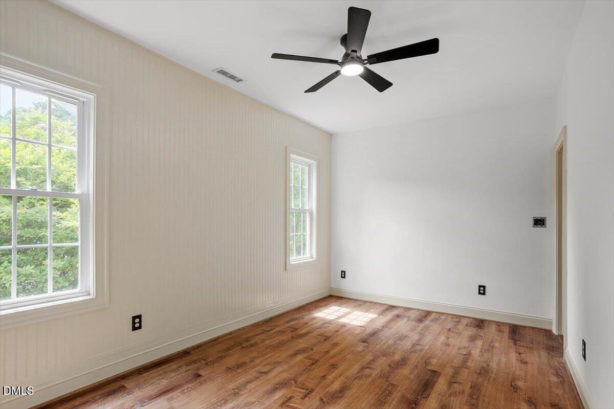 9113 Wellsley Way Raleigh, NC 27613 - Photo 30 of 44 an empty room with wooden floor fan and windows