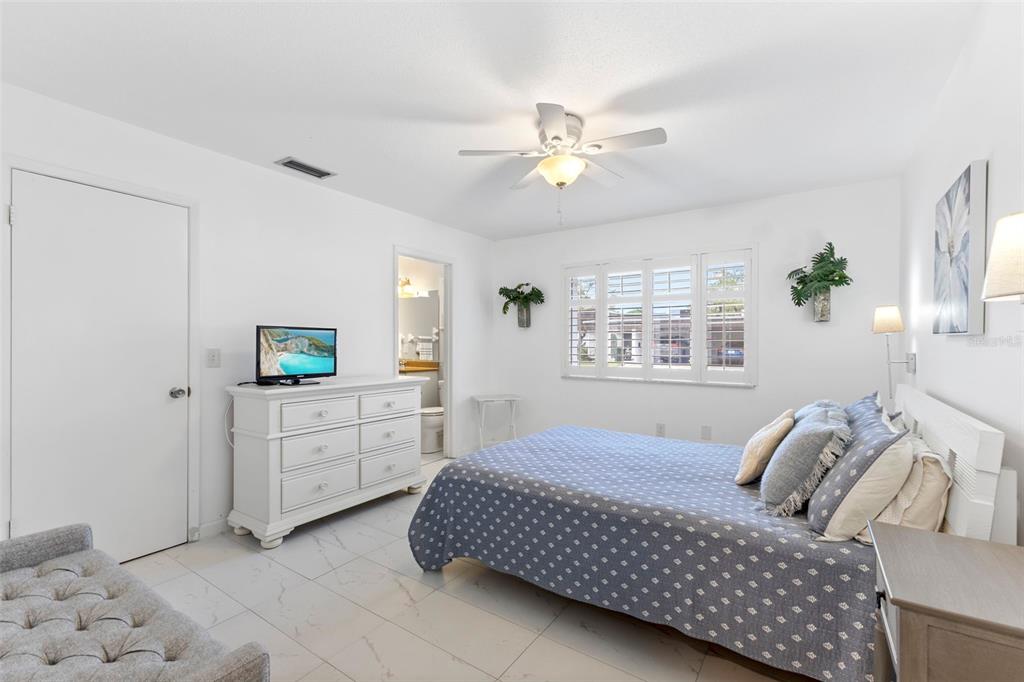 3978 Overlook Bend Terrace, Unit 25 Sarasota, FL 34232 - Photo 16 of 18 a bedroom with a bed and a chandelier