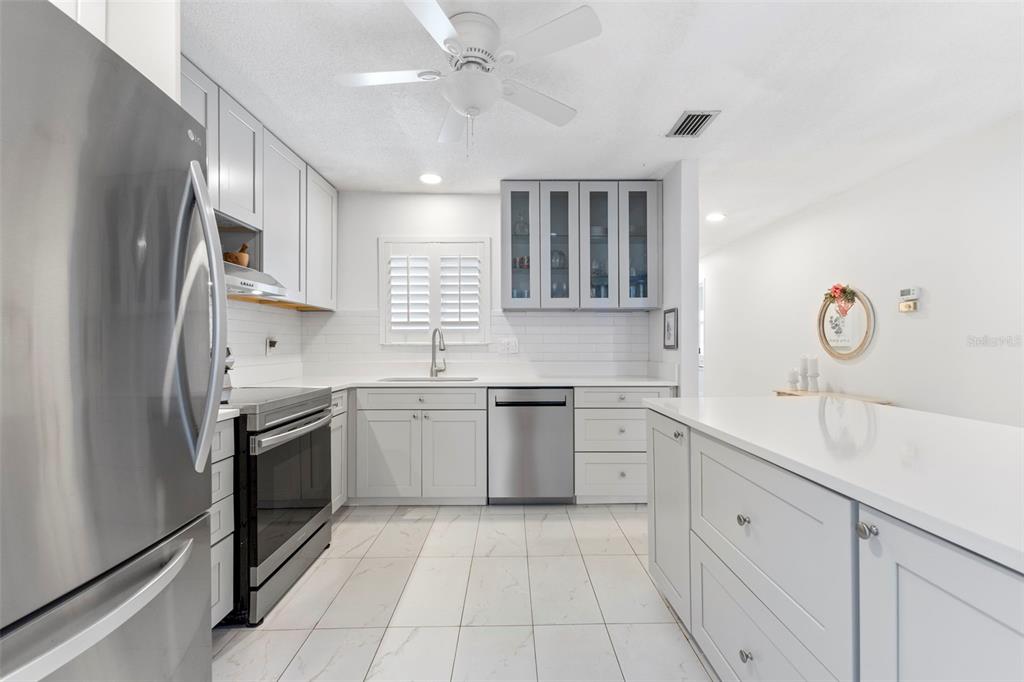 3978 Overlook Bend Terrace, Unit 25 Sarasota, FL 34232 - Photo 3 of 18 a kitchen with a sink stove and cabinets
