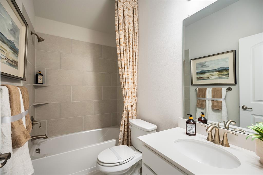 8716 Saratoga Street Pilot Point, TX 76258 - Photo 12 of 16 a bathroom with a bathtub shower sink vanity mirror and toilet