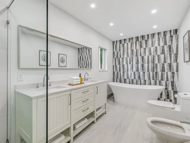 a bathroom with a double vanity sink a mirror and a bathtub