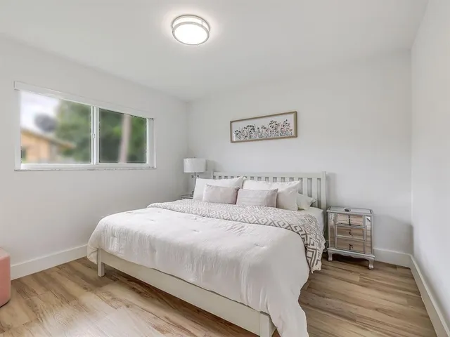 a bedroom with a bed and a night stand