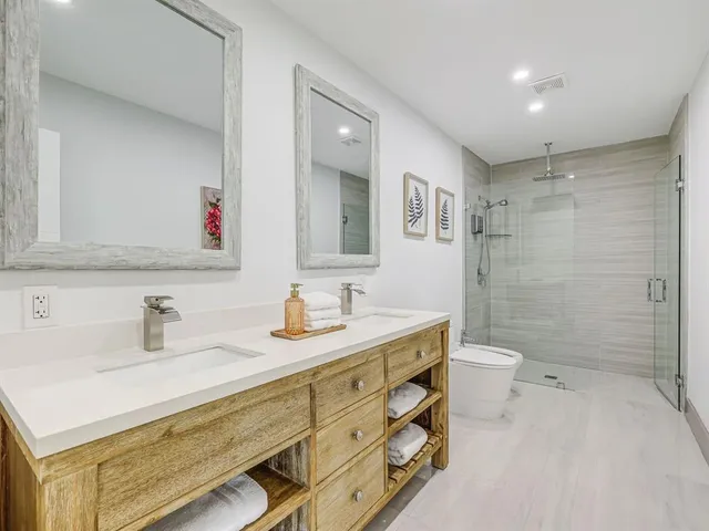 a bathroom with a sink a toilet a shower and a mirror