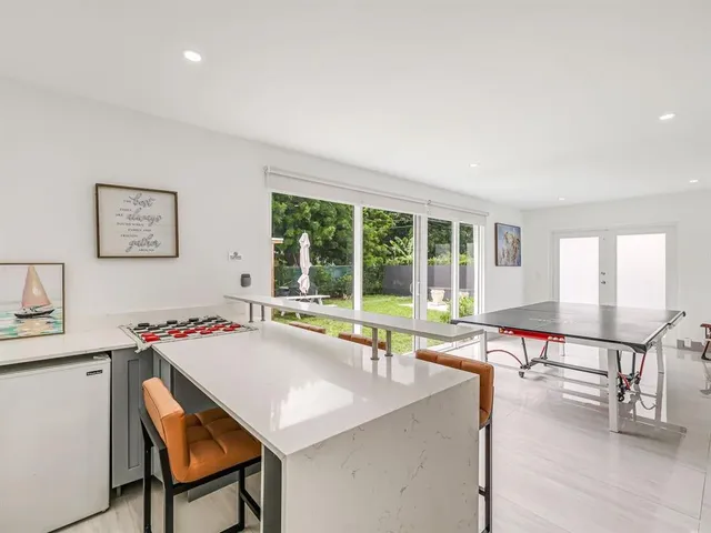 a living room with a table chairs and a refrigerator
