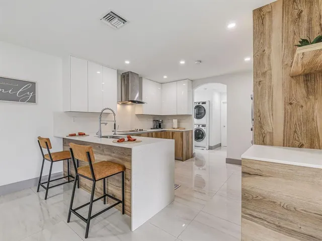 a kitchen with a table chairs refrigerator and microwave