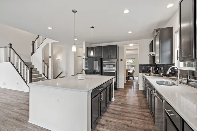 a kitchen with stainless steel appliances kitchen island a island in the center and wooden cabinets