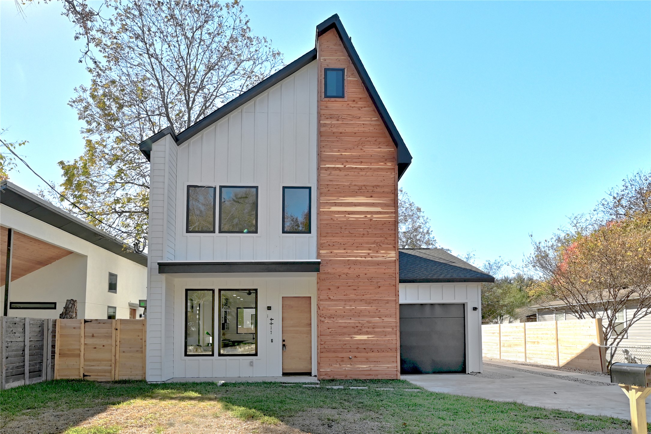 2717 Lyons Road, Unit 1 Austin, TX 78702 - Photo 2 of 34 Rear view of house with board and batten siding, a garage, and driveway
