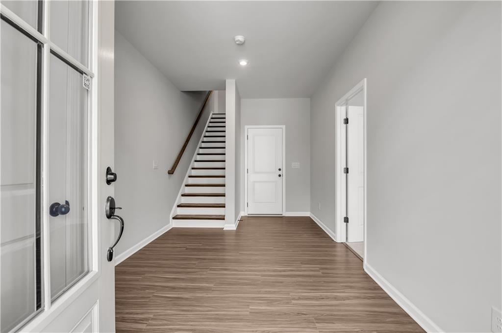 660 Devon Alley Acworth, GA 30102 - Photo 2 of 32 a view of a hallway with wooden floor and staircase