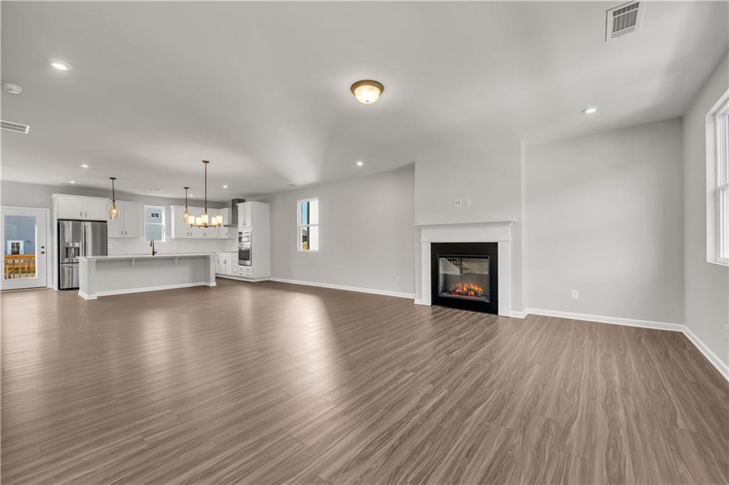 660 Devon Alley Acworth, GA 30102 - Photo 9 of 32 a view of a livingroom with wooden floor and a kitchen