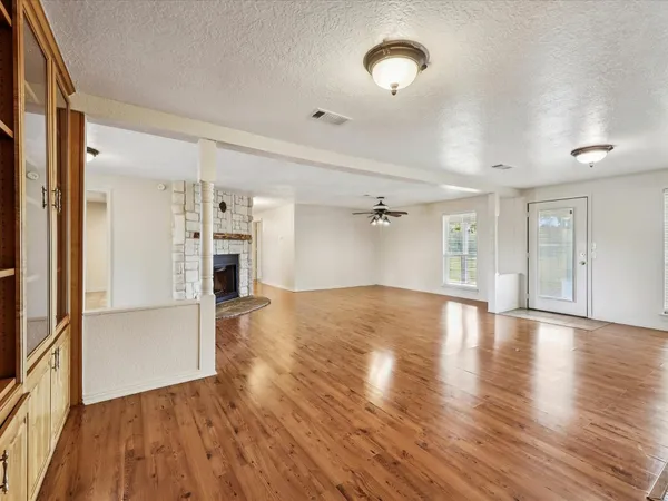 a view of a livingroom with wooden floor and a fireplace