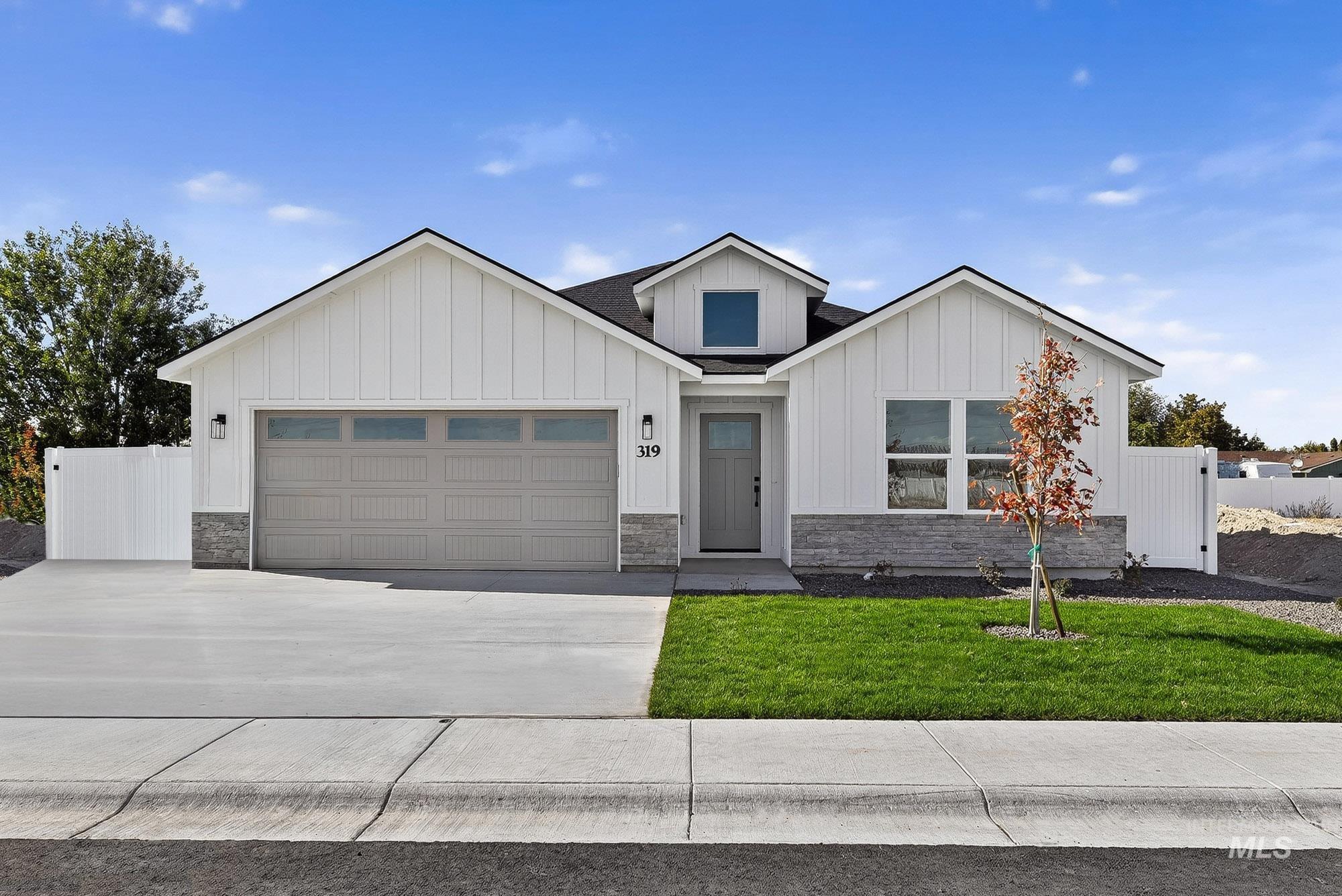 Modern inspired farmhouse featuring board and batten siding, stone siding, concrete driveway, and a garage