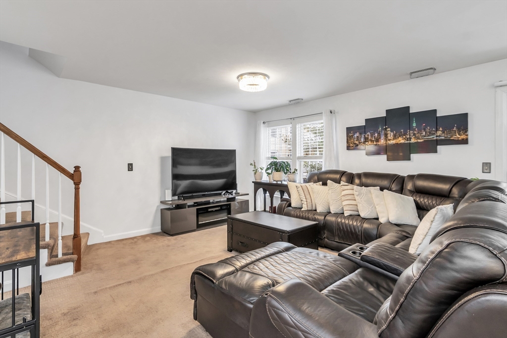 1 Riverview Boulevard, Unit 7204 Methuen, MA 01844 - Photo 6 of 29 a living room with furniture and a flat screen tv