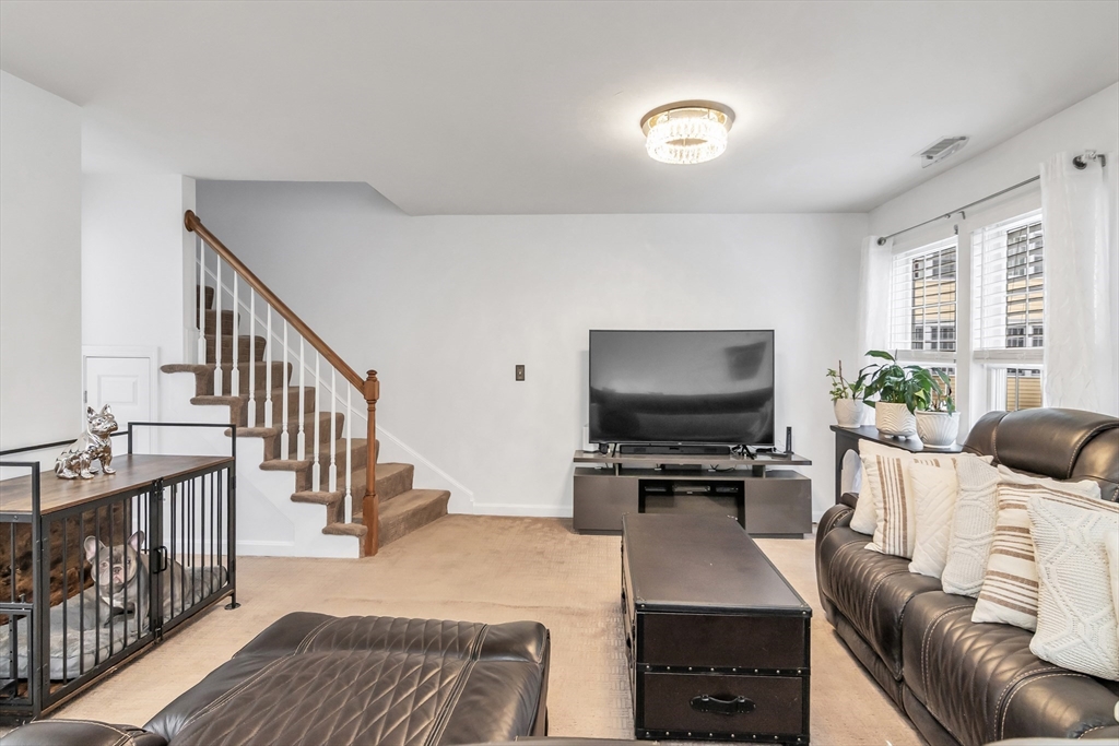 1 Riverview Boulevard, Unit 7204 Methuen, MA 01844 - Photo 7 of 29 a living room with furniture and a flat screen tv