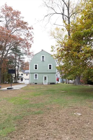 a front view of a house with a garden and trees