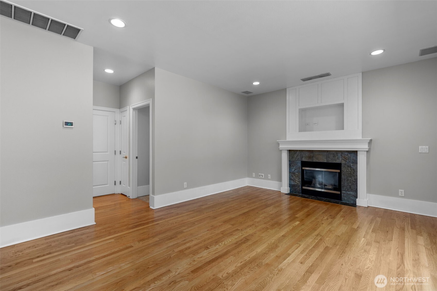 2528 Camas Avenue Northeast Renton, WA 98056 - Photo 21 of 28 a view of an empty room with wooden floor fireplace and a window