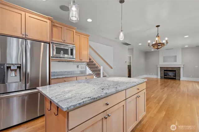 a kitchen with stainless steel appliances granite countertop a sink refrigerator and cabinets