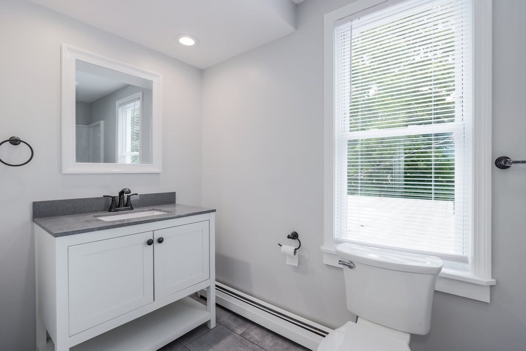 19 Converse Street Palmer, MA 01069 - Photo 21 of 28 a bathroom with a granite countertop sink a toilet and a mirror