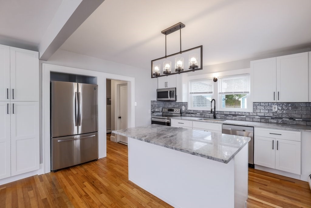19 Converse Street Palmer, MA 01069 - Photo 10 of 28 a kitchen with stainless steel appliances granite countertop a refrigerator a sink dishwasher a stove and white cabinets with wooden floor
