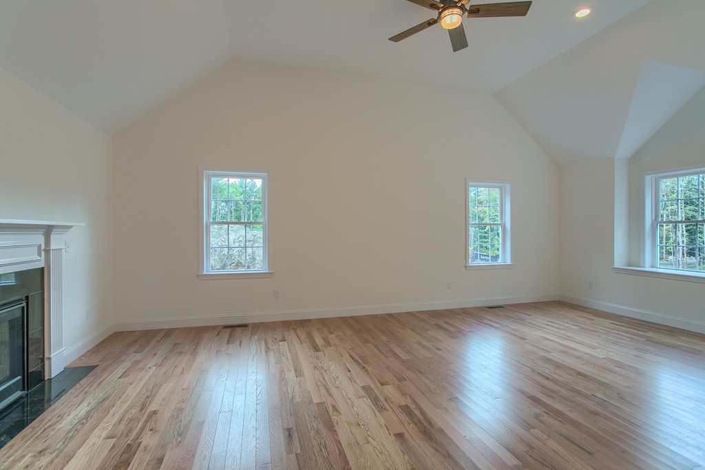 73 Meadow Road Townsend, MA 01469 - Photo 14 of 25 an empty room with wooden floor a ceiling fan and windows