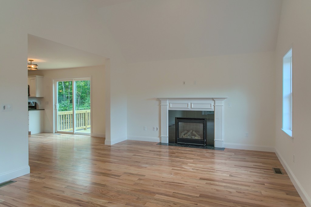 73 Meadow Road Townsend, MA 01469 - Photo 17 of 25 an empty room with wooden floor fireplace and windows
