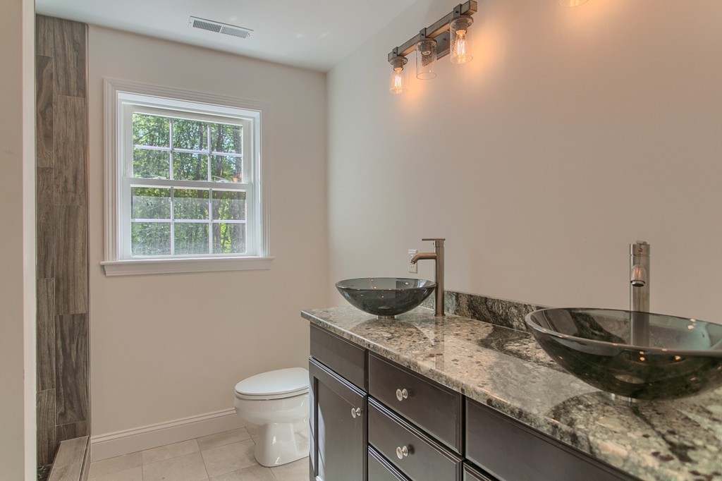 73 Meadow Road Townsend, MA 01469 - Photo 21 of 25 a bathroom with a granite countertop sink a toilet and a window