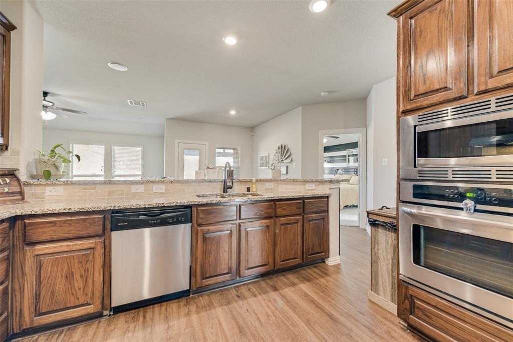 343 Amber Lane Nevada, TX 75173 - Photo 11 of 33 a kitchen with stainless steel appliances granite countertop hardwood floor sink and stove
