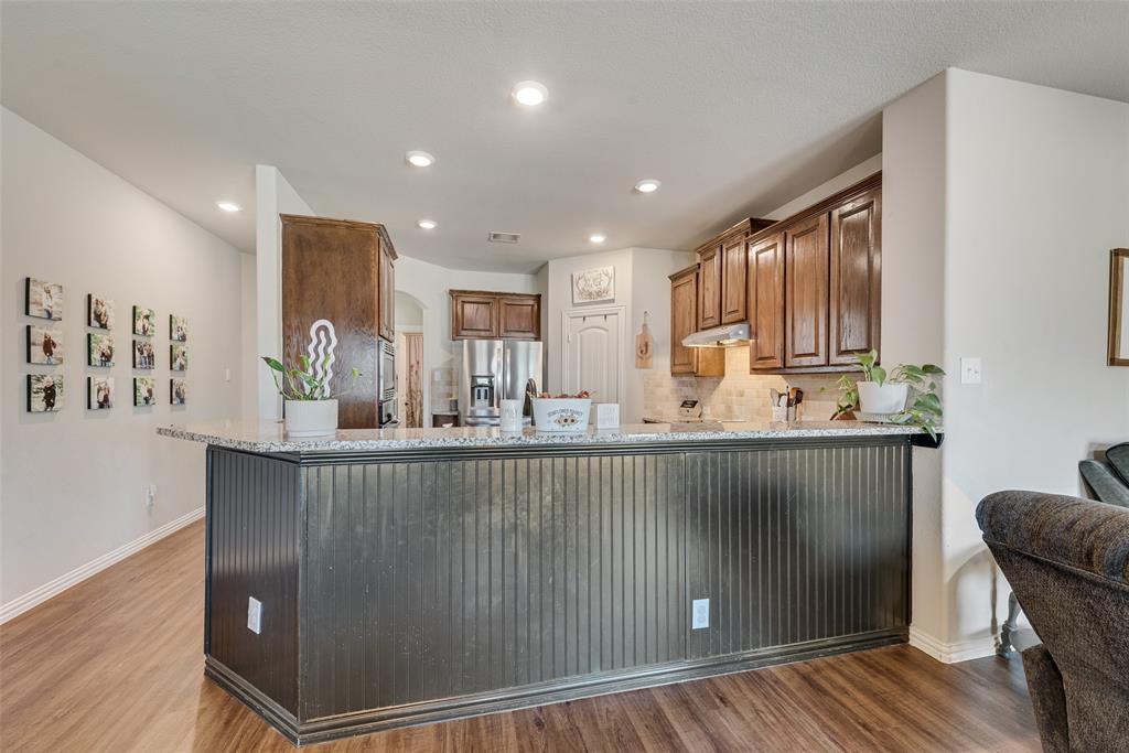 343 Amber Lane Nevada, TX 75173 - Photo 13 of 33 a kitchen with stainless steel appliances granite countertop a refrigerator a sink a stove and wooden floors