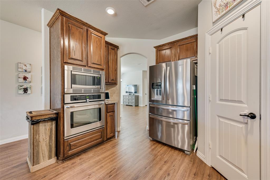 343 Amber Lane Nevada, TX 75173 - Photo 10 of 33 a kitchen with stainless steel appliances a refrigerator stove and wooden floor