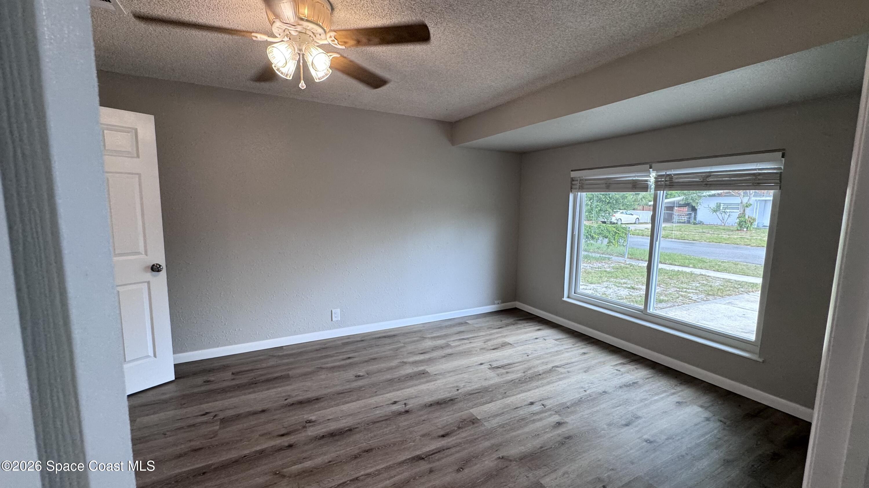 2137 Laden Road Melbourne, FL 32935 - Photo 7 of 23 a view of an empty room with wooden floor and a window