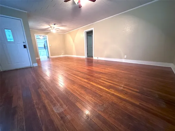 a view of an empty room with wooden floor