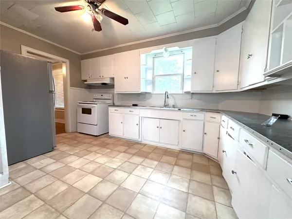 a large white kitchen with cabinets