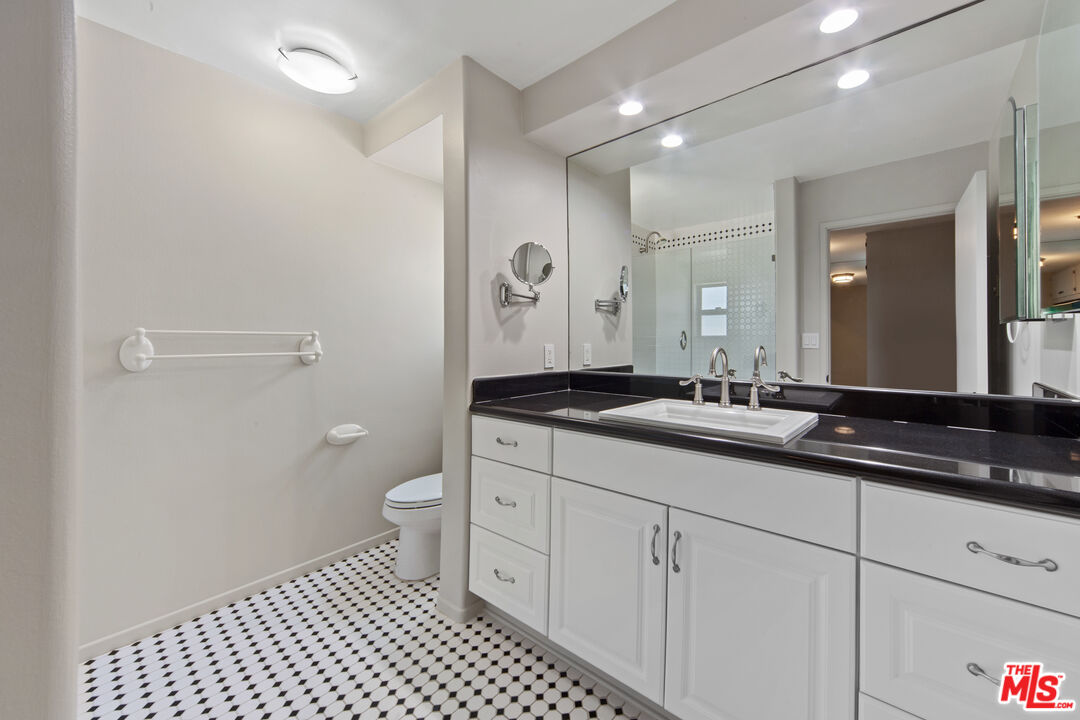 25218 Malibu Road Malibu, CA 90265 - Photo 6 of 9 a bathroom with a granite countertop sink a toilet and a mirror