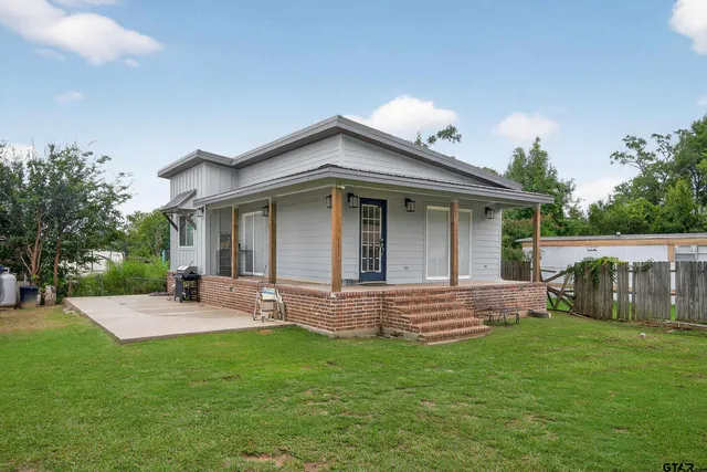 a backyard of a house with table and chairs