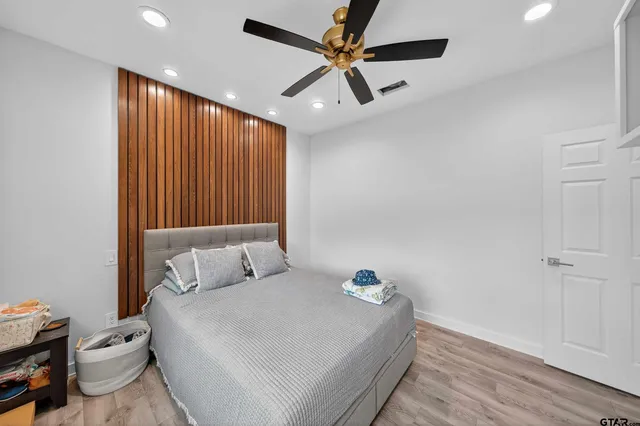 a bedroom with a bed and a ceiling fan