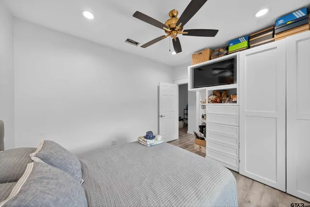 a bed room with a bed and a ceiling fan