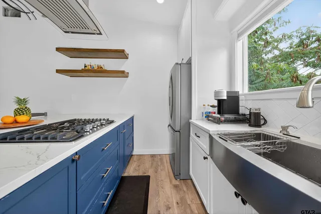 a kitchen with stainless steel appliances granite countertop a stove a sink and a refrigerator