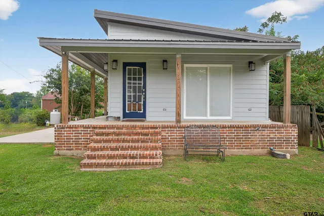 a backyard of a house with barbeque oven table and chairs