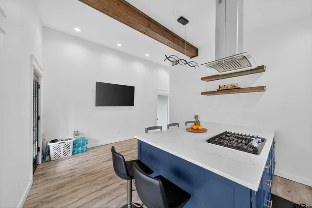 a kitchen with a sink appliances and wooden floor