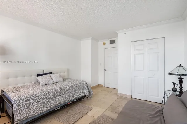 a bedroom with a bed and a flat tv screen on a dresser
