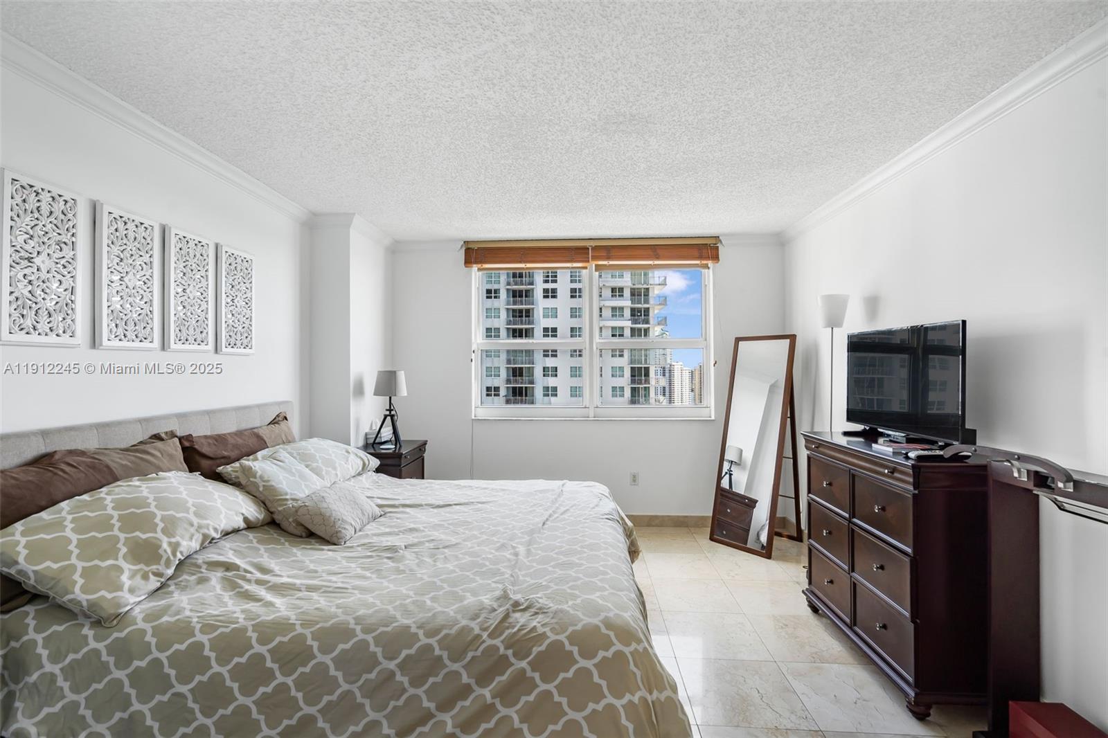 1155 Brickell Bay Drive, Unit 2708 Miami, FL 33131 - Photo 15 of 19 a bedroom with a bed and a flat tv screen on a dresser