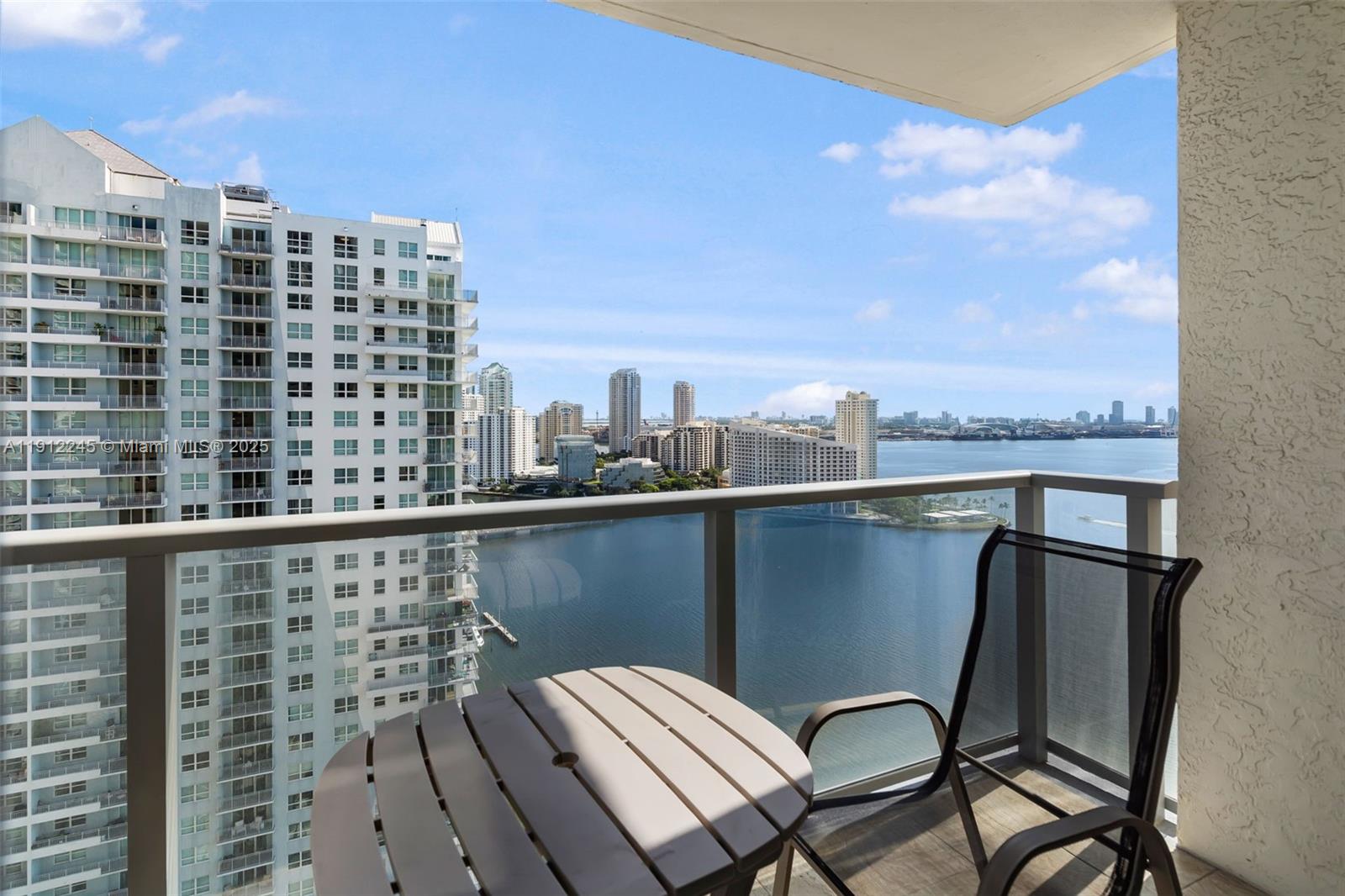 1155 Brickell Bay Drive, Unit 2708 Miami, FL 33131 - Photo 2 of 19 a view of a balcony with two chairs and a table